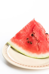 Triangle slice of watermelon on the plate isolated over white background