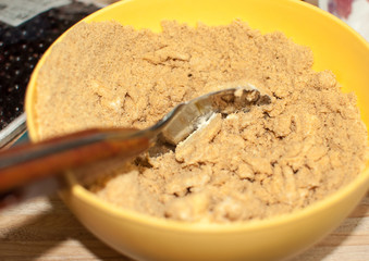Biscuit crumbs and butter in yellow bowl close up