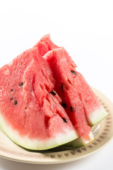 Slices of watermelon on the plate above white background