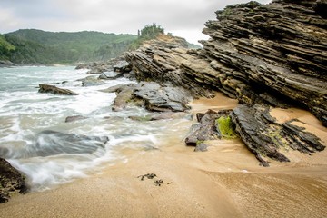 rocks in the beach with blurry waves