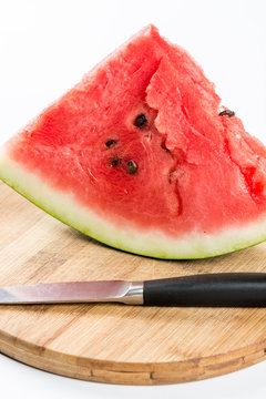Sliced watermelon on the wooden board with knife