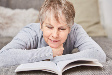 Seniorin liest ein spannendes Buch