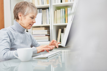 Seniorin arbeitet am Computer