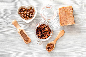 Homemade skin care. Coffee soap, coffee scrub, coffee grains on wooden background top view