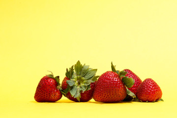 A pile of strawberries  isolated on yellow background