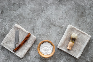 Fototapeta na wymiar Preparing for men shaving. Shaving brush, razor, foam on grey stone table background top view copyspace