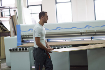 worker in a factory of wooden furniture