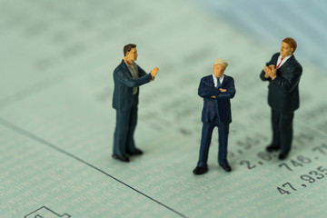 Miniature businessman standing on bank account book and others clapping as business financial concept