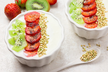Raw vegan breakfast bowl with strawberry and kiwi. 