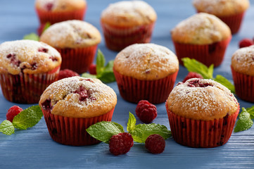 Sweet homemade raspberry muffins on wooden table.