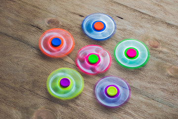 Colored fidget spinners stress relieving toy on wooden background
