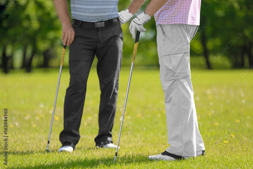 Wall mural Young men on golf course in sunny day