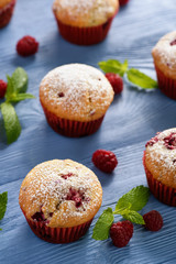 Sweet homemade raspberry muffins on wooden table.