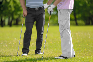Young men on golf course in sunny day