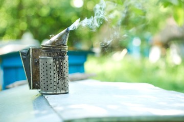 Shot of a metal bee smoker smoking in apiary outdoors on a sunny warm day copyspace nature tool equipment beekeeping apiculture bee house honey production concept.