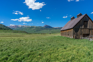 Fototapeta na wymiar Barn overlooking meadow in high Rocky Mountains