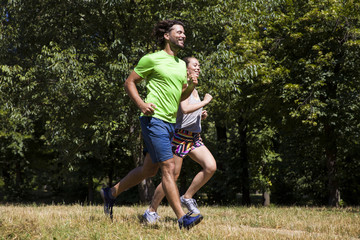 Young couple running in the park on a sunny day