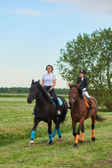 Pretty little girl jockey and her coach ridding a horse