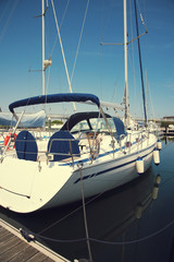 Fototapeta premium White yacht in the port waiting. On the sea is calm.