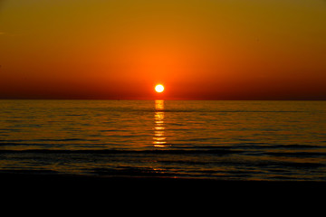 Fototapeta na wymiar sunset over ocean red skies 