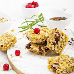 Cereal bars with red berries, honey for a healthy snack on a light background with flax seeds, sesame. Top View