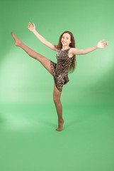 Beautiful girl dancing in trendy pantera dress and raised her leg up © Akova