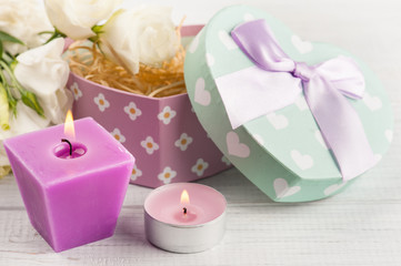 Fototapeta na wymiar Arrangement of candles, flowers, pastel gift box