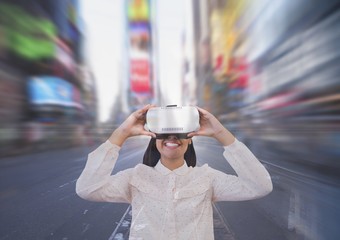 Happy woman in VR headset looking against city background