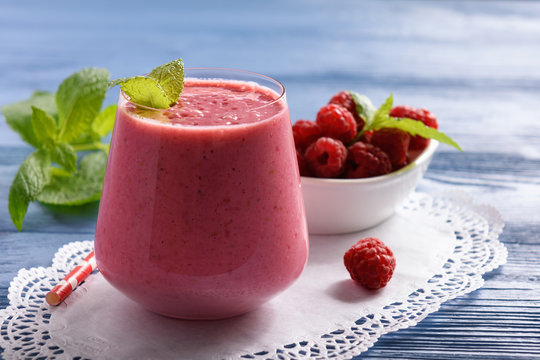 Healthy beverage - raspberry milkshake on wooden table.