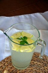 Fresh cold lemonade with a piece of lemon, ice and ginger on a glass.