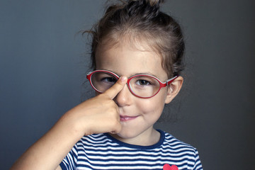 The child adjusts his glasses with his finger. Honors pupil. Correction of vision in preschool...