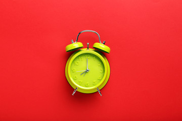 Green alarm clock on the red background
