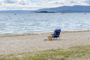 man in the beach deck chairs on the beach, rear view