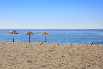 Trzy parasole na tropikalnej plaży wyspy Rodos w Grecji. - obrazy, fototapety, plakaty