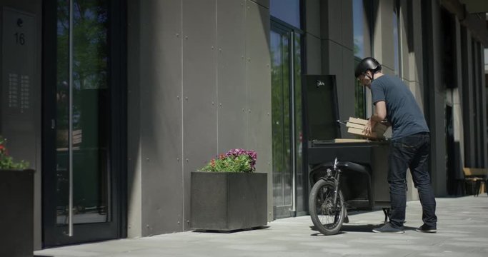 Handsome bike courier unloads his cargo bike