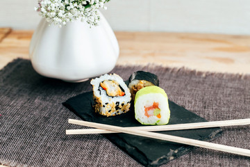 Selective focus photo of tiny japanese rice makis sushi, made from fresh seafood and vegetables, delicious savoury tasty tapas in restaurant or cafe