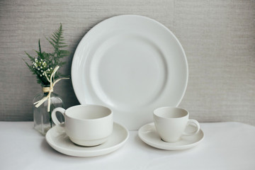 Set of beautiful exquisite dinnerware and cups made from white luxurious china and porcelain, set up for mockup on isolated background
