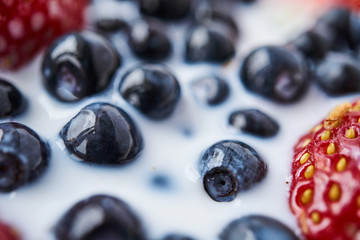 Strawberries, blueberries and milk in a white bowl