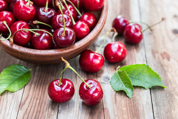 cherries in bowl on wooden background .