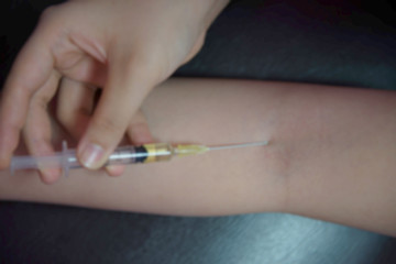 Obraz na płótnie Canvas Background blur addiction is using a syringe.