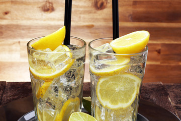 Lemonade with fresh lemon on wooden background