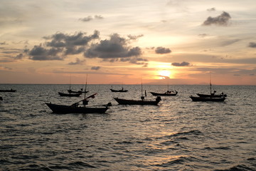Beautiful sunset and silhouette fisherman boat in the ocean