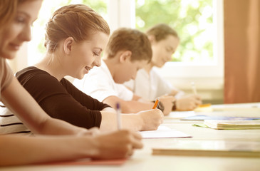 Students or pupils writing test in school being concentrated