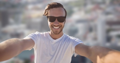 Man taking selfie against blurry city