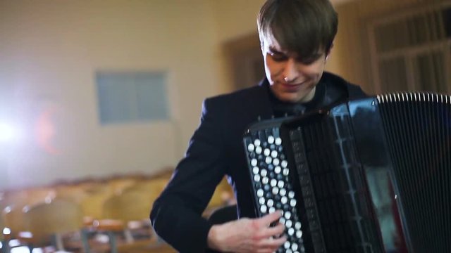 The face of the accordionist. Fingers of accordionist on the keys