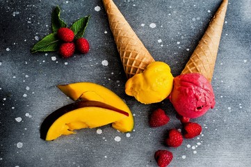 Ice cream in a glass cube with raspberries and mango