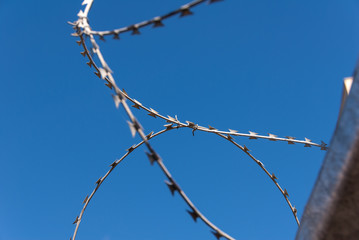 Barbed wire against the blue sky