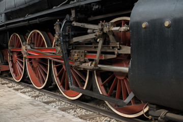  Wheels of an old steam locomotive close up. Train on the rails.