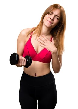 Beautiful sport woman with dumbbells with heart pain