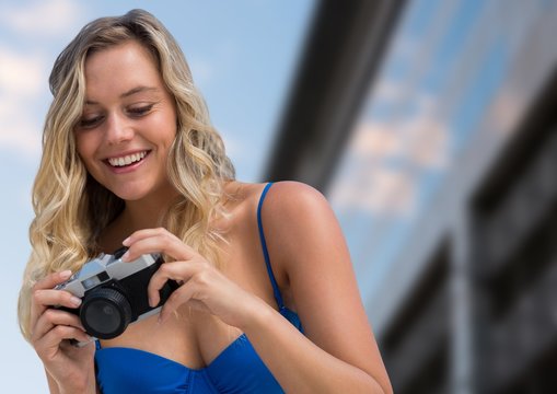 Millennial Woman Looking Down At Camera Against Blurry Building